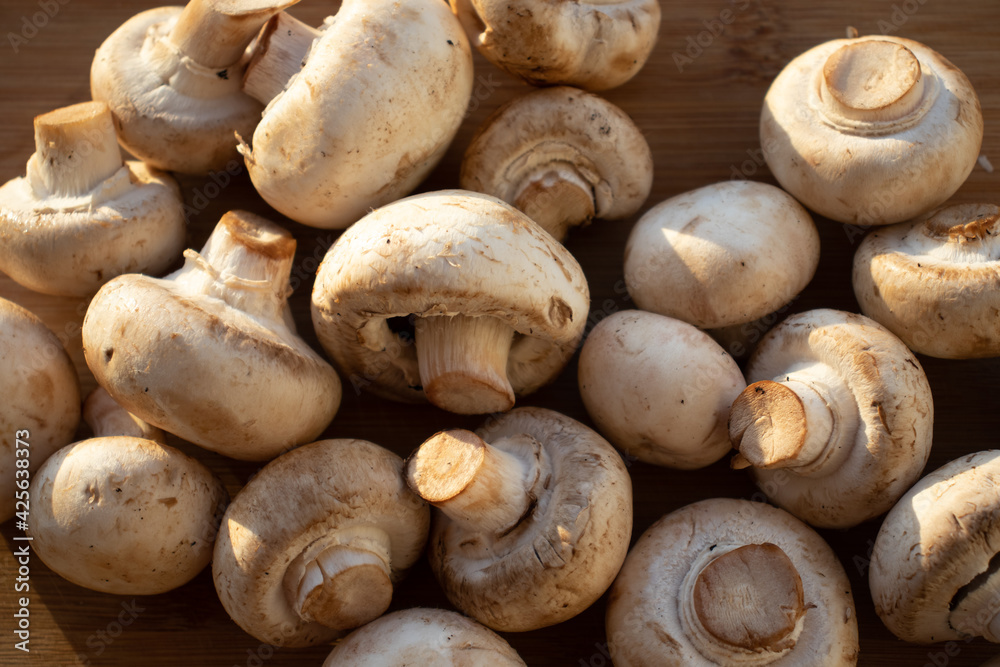 Fresh healthy brown mushrooms with very shallow depth of field. Mushrooms and champignons on the table. Mushrooms on the table top view Fresh healthy brown mushrooms with very shallow depth of field. Mushrooms and champignons on the table. Mushrooms on the table top view