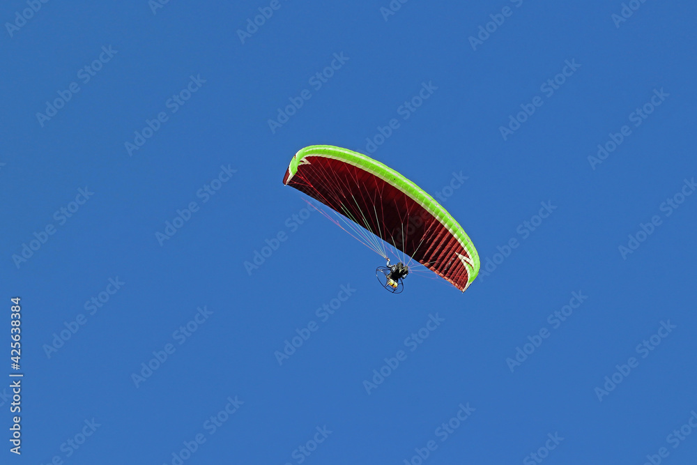 Motorschirm im Flug gegen den blauen Himmel. Ein Paraglider mit Motor Motorschirm im Flug gegen den blauen Himmel. Ein Paraglider mit Motor