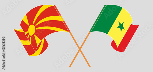 Crossed and waving flags of North Macedonia and Senegal