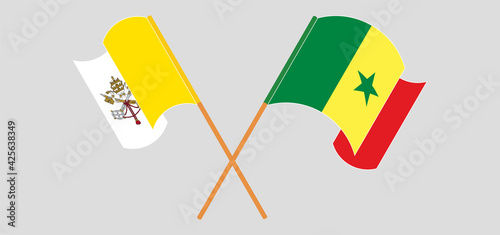 Crossed and waving flags of Vatican and Senegal