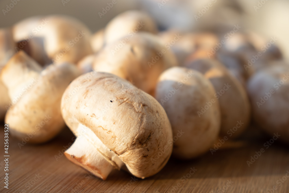 Fresh healthy brown mushrooms with very shallow depth of field. Mushrooms and champignons on the table. Mushrooms on the table top view Fresh healthy brown mushrooms with very shallow depth of field. Mushrooms and champignons on the table. Mushrooms on the table top view