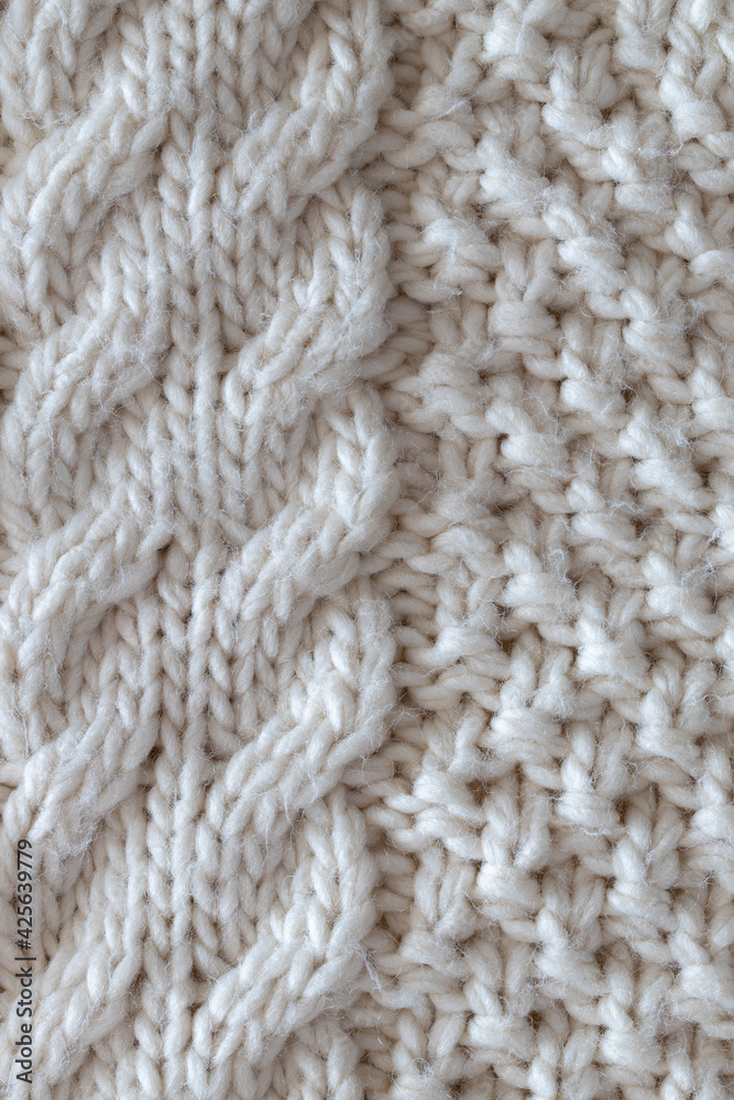 Background from beautiful, knitted background, Aran pattern, weave from braids. Concept handicrafts, DIY, leisure, fashionable warm clothes, hobbies. Top view, macro, close-up, flat lay. Vertical Background from beautiful, knitted background, Aran pattern, weave from braids. Concept handicrafts, DIY, leisure, fashionable warm clothes, hobbies. Top view, macro, close-up, flat lay. Vertical