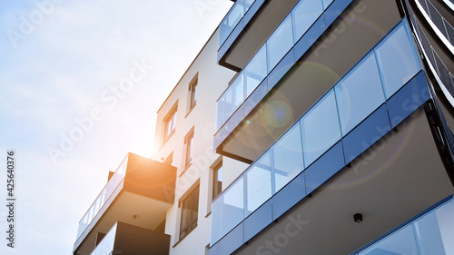 Image of condo on afternoon with sun set. Contemporary white residential building against a blue sky. Ideal for illustration of real estate or investment concepts. © Grand Warszawski