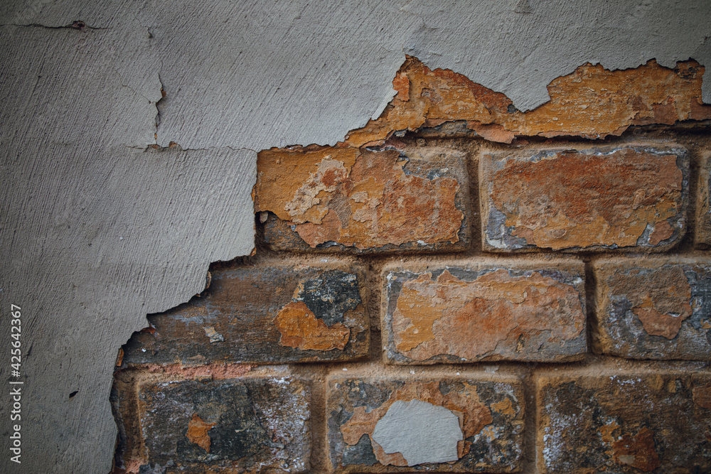 Texture of old peeling paint on a brick wall. peeling putty on a brick