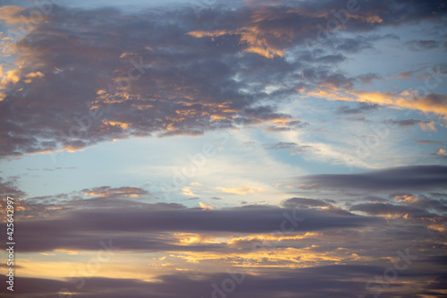 Colorful clouds in a dramatic blue sky with gray and orange colors © Adilson