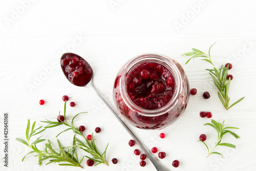Bilde på lerret lingonberry sauce with rosemary in a glass jar on a light wooden table