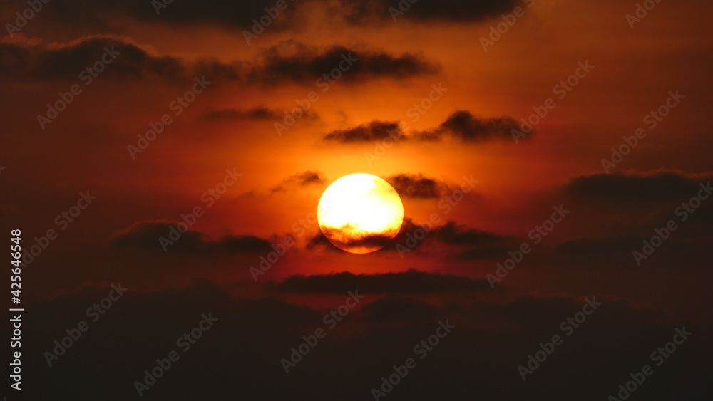 Sunset in the maldives with sun partly covered by clouds Sunset in the maldives with sun partly covered by clouds
