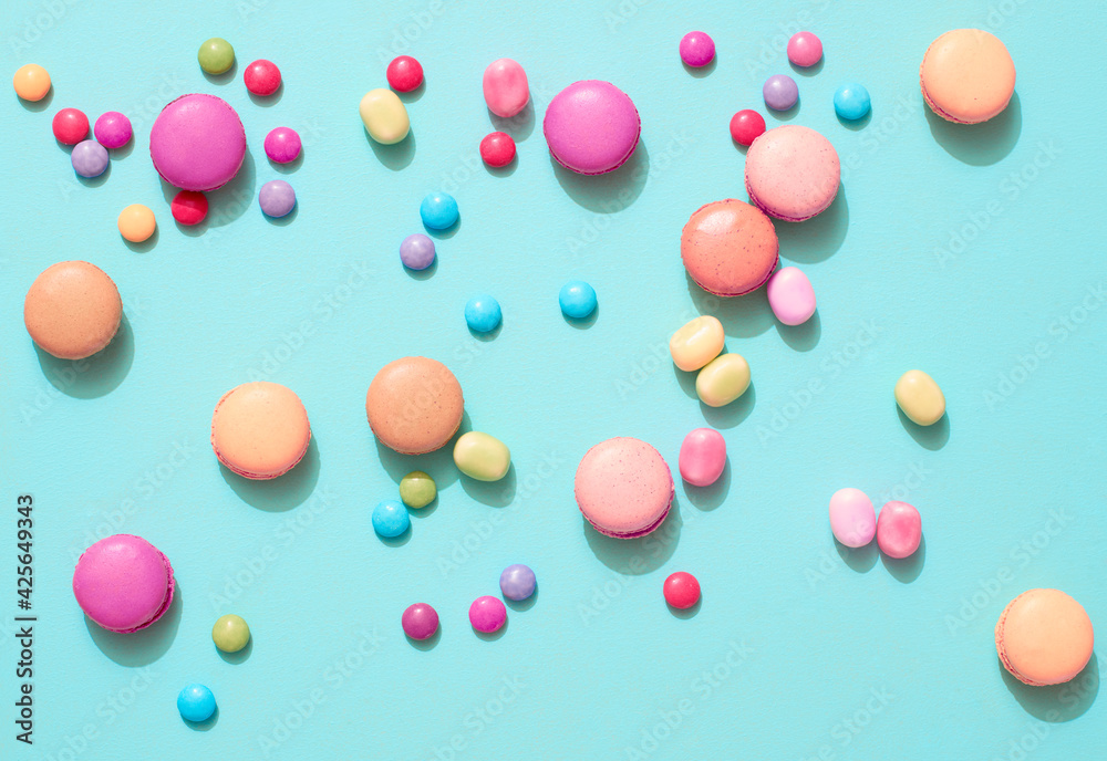 Delicious macarons with candies on a vibrant colorful background with copyspace Delicious macarons with candies on a vibrant colorful background with copyspace