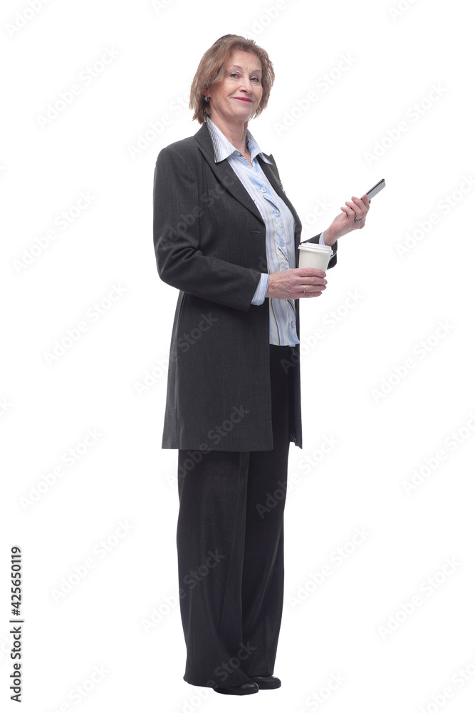 Senior smiling lady is standing with smart phone in hands and cup of coffee Senior smiling lady is standing with smart phone in hands and cup of coffee