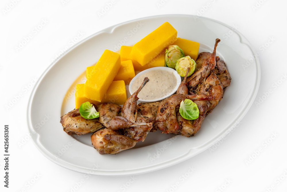 Grilled quails in a sauce with vegetables and herbs. Gentle, diet poultry meat. Banquet festive dishes. Gourmet restaurant menu. White background.