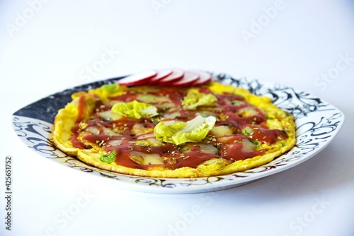 Juicy pizza omelet with ham and spring onions  spices  lettuce  radishes  topped with tomatoes and melted cheese