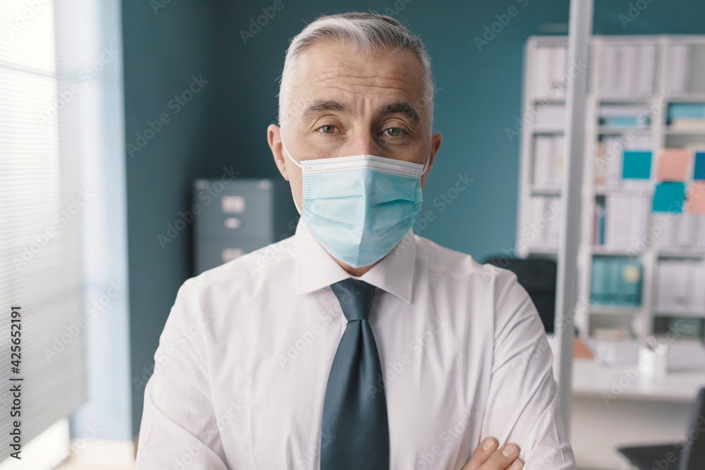 Confident corporate businessman with surgical mask Confident corporate businessman with surgical mask