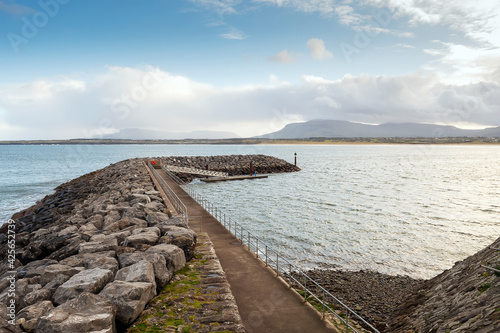 Stone build structure of Mullaghmore harbor. County Sligo, Ireland. Benbulben flat top mountain in the background. Low cloudy sky. photo