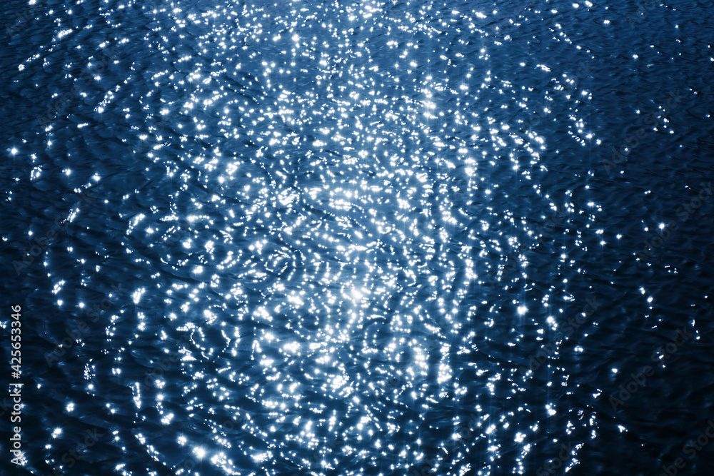 Ripples on lake water. Sunlight reflecting in water. Sun shining by the lake. Ocean wave background. Wavy pond texture. Messy water flow. Blue water surface background. Dark ocean depth.