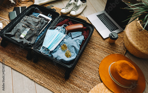 Fototapeta Packing suitcase for travel vacation in new normal