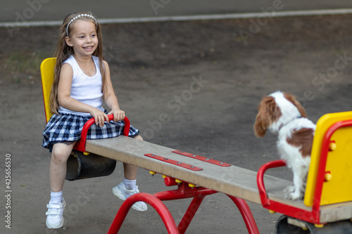 Girl riding on a swing with her favorite dog