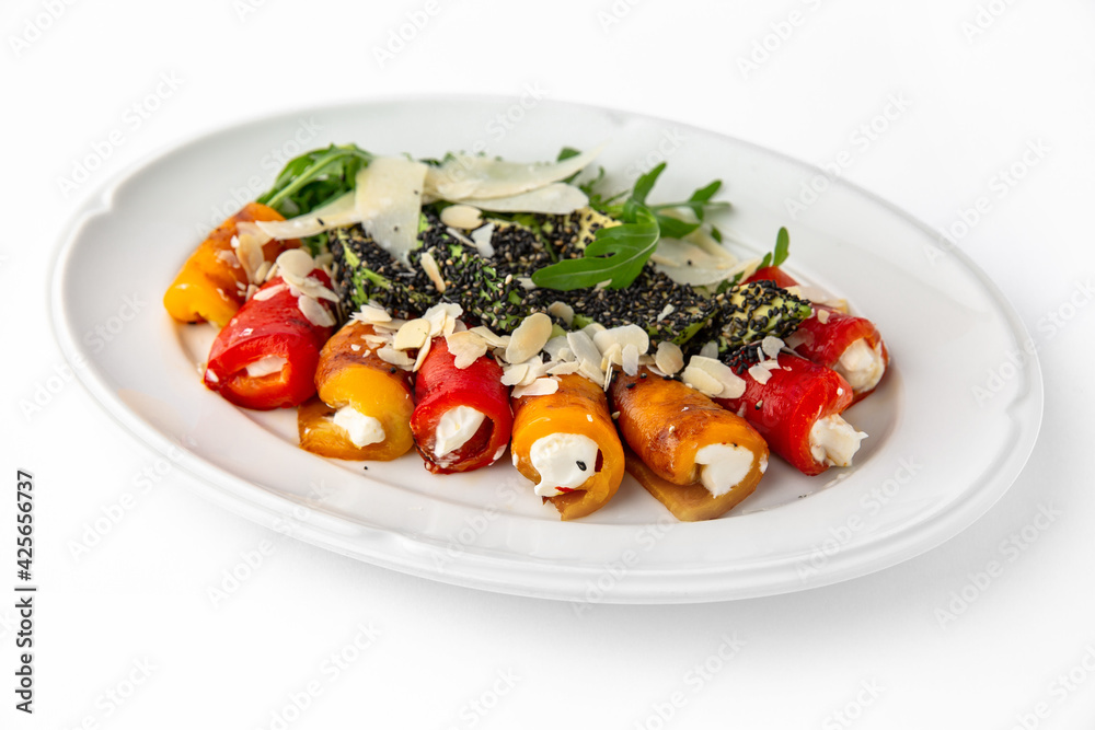 Appetizer of grilled sweet peppers. Rolls stuffed with cheese. Banquet festive dishes. Gourmet restaurant menu. White background.