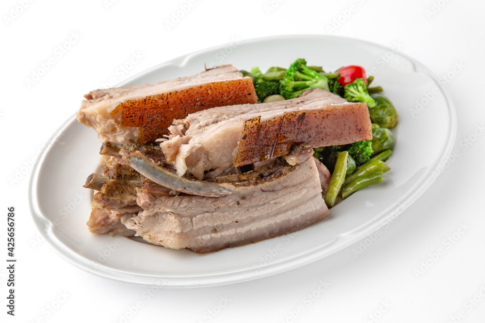 Large pieces of pork baked in spices. Banquet festive dishes. Gourmet restaurant menu. White background.