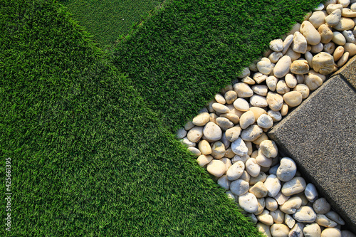 Artificial turf is decorated with white pebbles.
