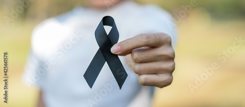 Melanoma and skin cancer, Vaccine injury awareness month and rest in peace concepts. Woman holding black Ribbon