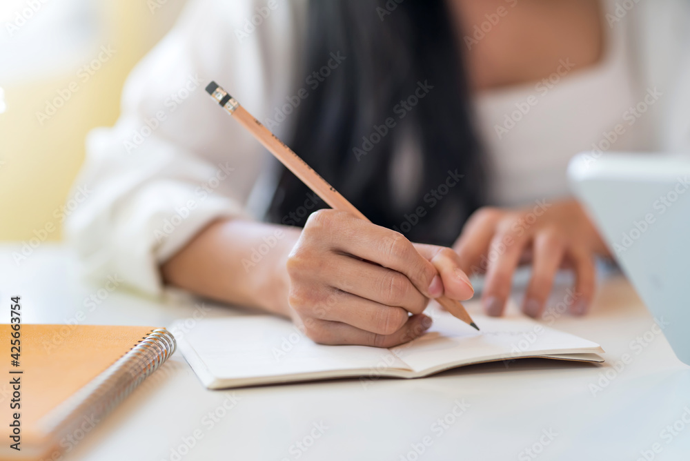Close up. Woman hand with a pencil taking notes at the office. Close up. Woman hand with a pencil taking notes at the office.