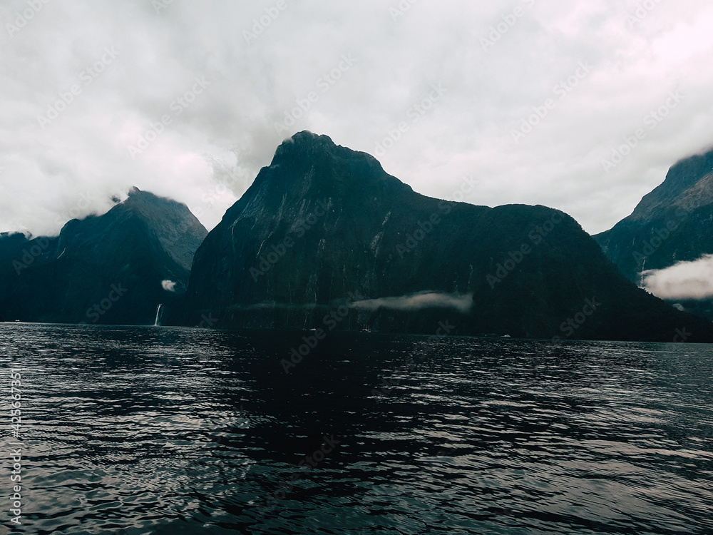 series of waterfalls with a visual on a boat in milford sounds