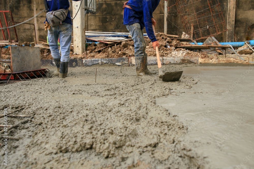 Construction workers scour the concrete with a shovel. Construction workers scour the concrete with a shovel.