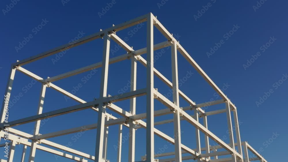 Abstract white metal construction: square and cube shaped cage like steel structure isolated against clear dark blue sky. Engineering, technology, development or building concept. Abstract white metal construction: square and cube shaped cage like steel structure isolated against clear dark blue sky. Engineering, technology, development or building concept.