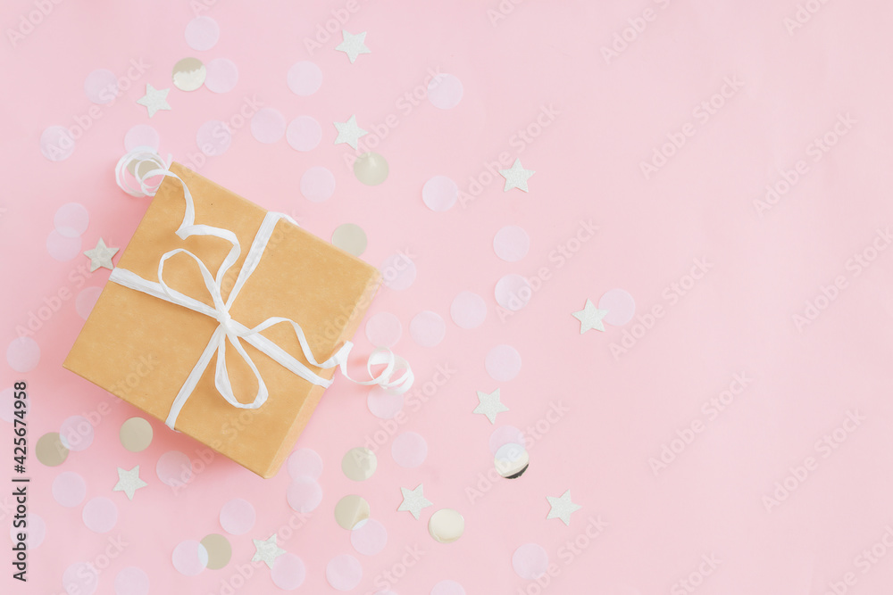 Fototapeta premium Paper gift box tied with ribbon, star and circle paper confetti or glitters