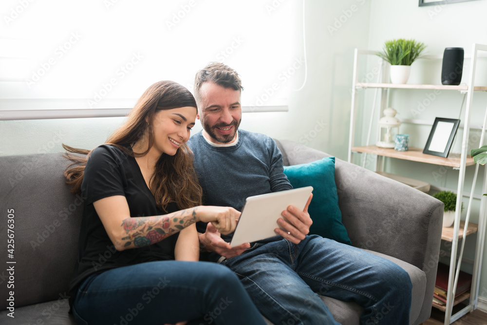 Attractive couple using a tablet in the living room Attractive couple using a tablet in the living room