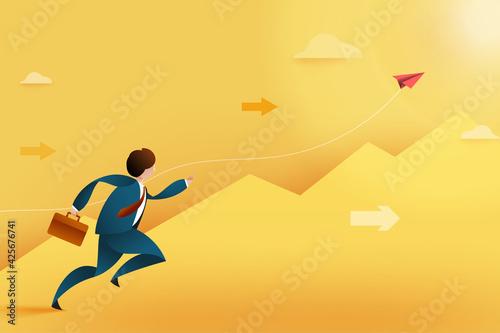 Young businessman running forward to rising red paper plane above the mountains.Business concept of growth and skill.