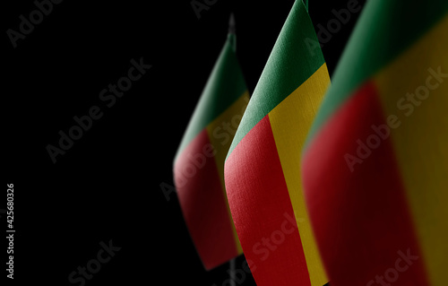 Small national flags of the Benin on a black background