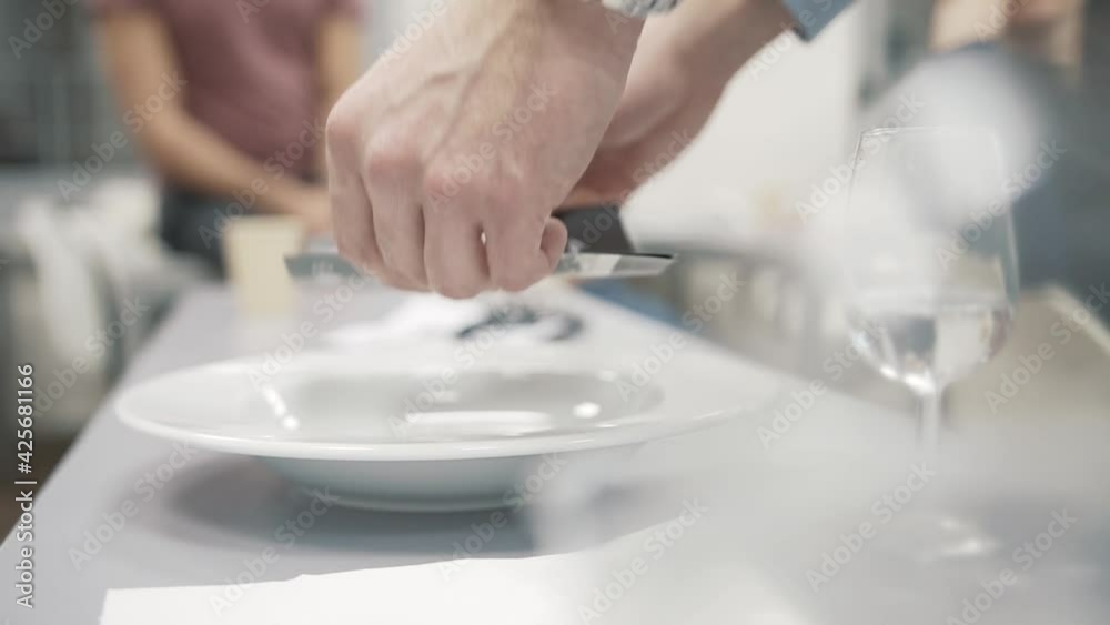 Waiter is putting menu into white bowl, luxury preparation in close up Waiter is putting menu into white bowl, luxury preparation in close up