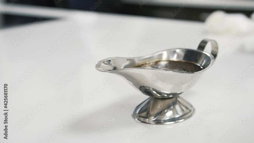 Close up of silver gravy boat on white table. Handheld Close up of silver gravy boat on white table. Handheld