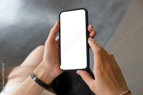 Close-up of woman's hands holding blank screen smartphone.