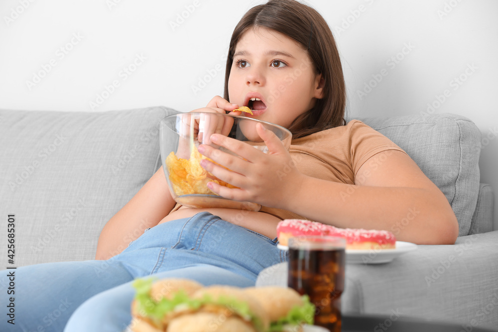 Overweight girl eating unhealthy food at home Overweight girl eating unhealthy food at home