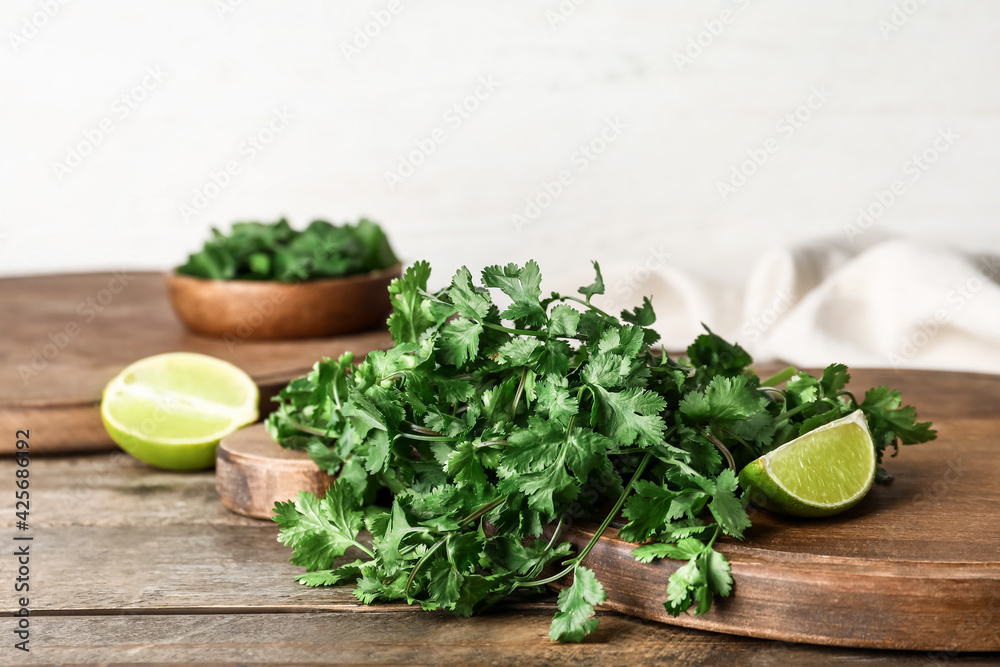 Boards with fresh cilantro and lime on wooden table Boards with fresh cilantro and lime on wooden table