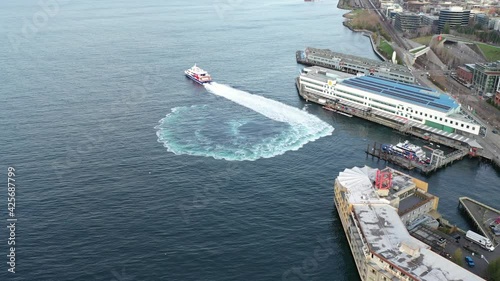 Sunrise cinematic drone aerial dolly shot of the ferry departing to Victoria from the Seattle waterfront, by the cruise terminal, Pike Place, Elliott Bay, Myrtle Edwards Park, Olympic Sculpture Park photo