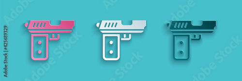 Paper cut Pistol or gun icon isolated on blue background. Police or military handgun. Small firearm. Paper art style. Vector