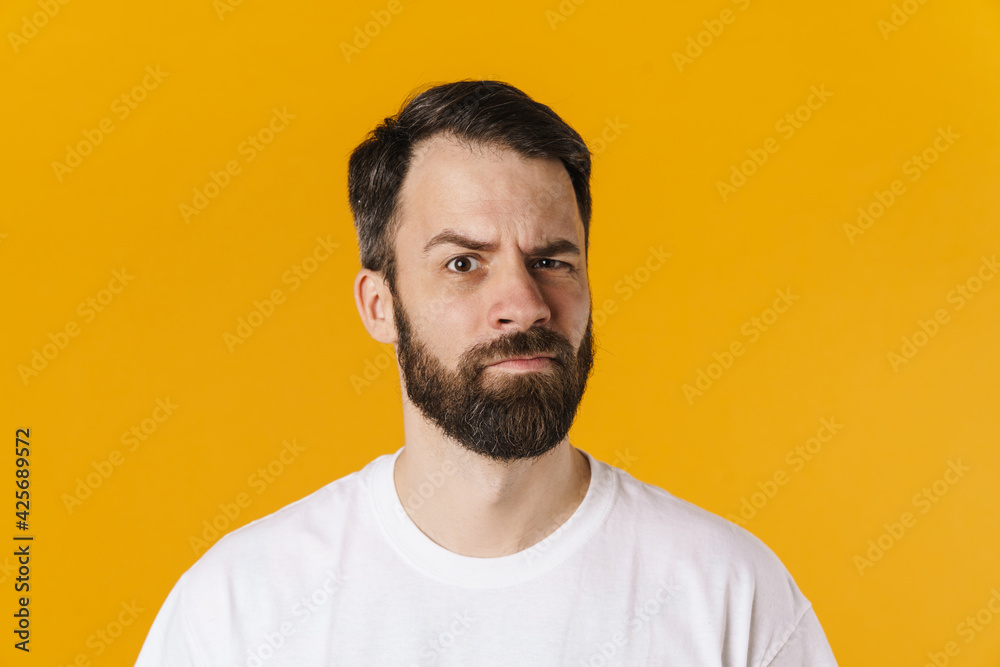 Obraz premium Portrait of a confused brunette bearded man standing