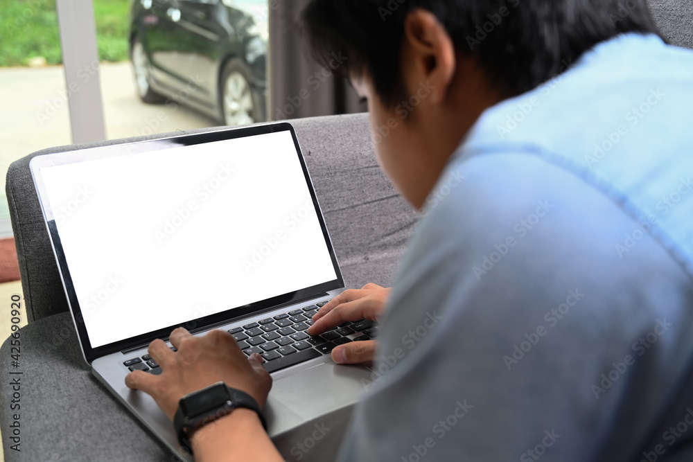 Close up view of casual man lying on comfortable sofa and working online with computer laptop. Close up view of casual man lying on comfortable sofa and working online with computer laptop.