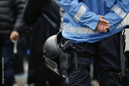 Details with the riot kit of a Romanian jandarm during a rally: gun, helmet, radio station, baton.