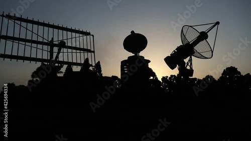 Space radar antenna on sunset. Silhouettes of satellite dishes or radio antennas against night sky. Creative artwork decoration. Selective focus