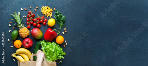 Human hand holding a paper bag with vegetarian food