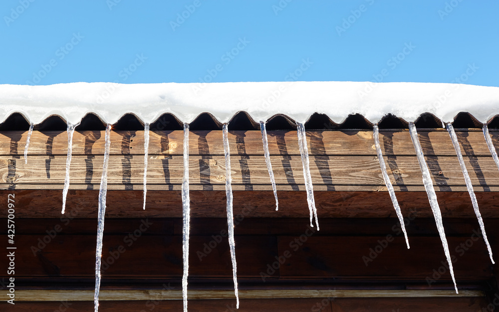 Icicles in winter. Ice stalactite hanging from the roof of building