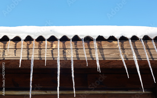 Icicles in winter. Ice stalactite hanging from the roof of building © supersomik