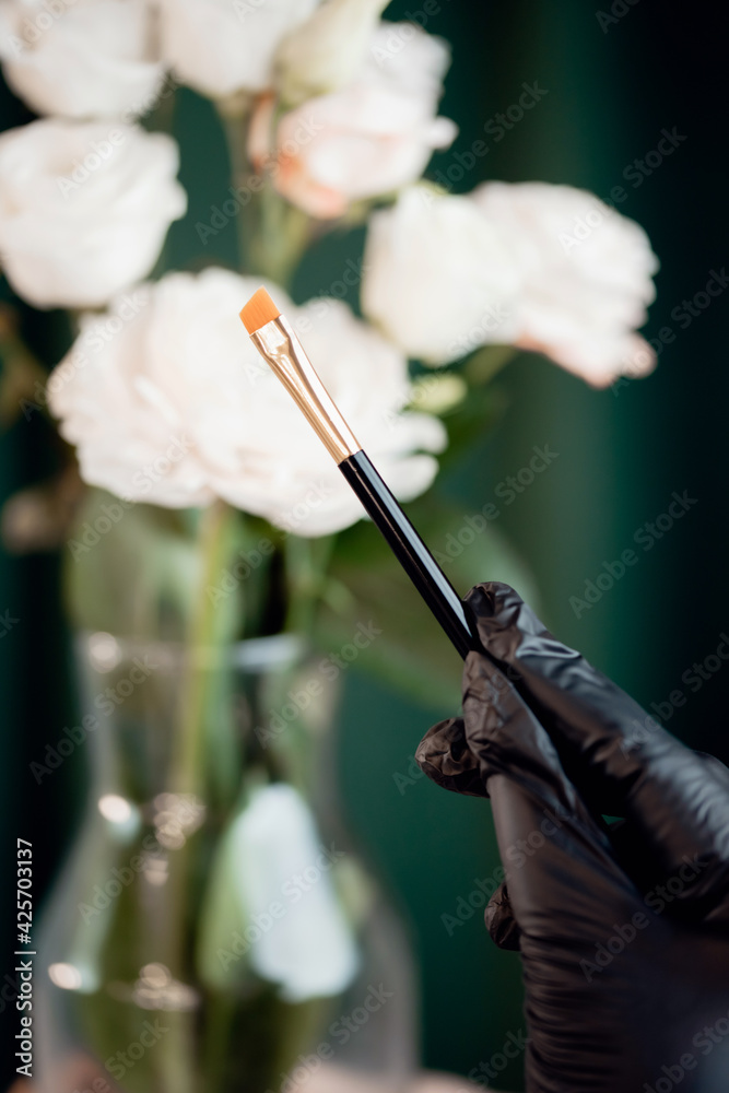 Naklejka premium Closeup cosmetic makeup brushes on hand master white background copy space