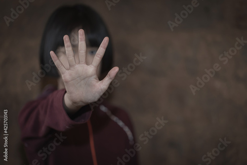 Kid girl showing hand signaling to stop useful to campaign against violence and pain. Stop abusing , terrified , A fearful child, human rights