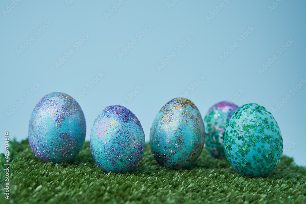 Blue painted eggs with bright shiny gliter on grass Blue painted eggs with bright shiny gliter on grass