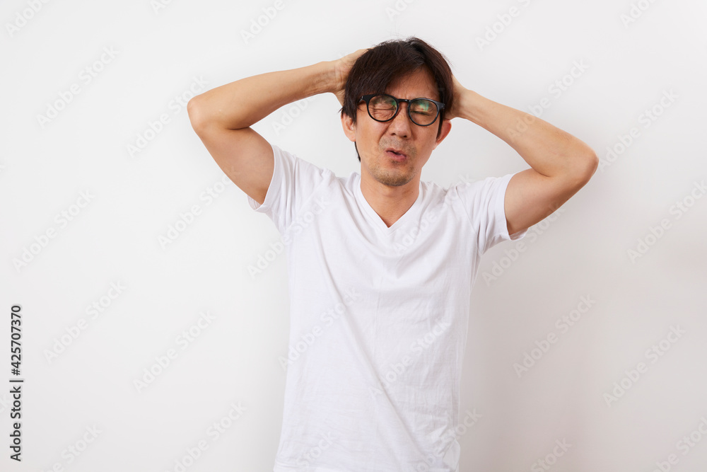 Asian middle-aged men having a headache stand on white background, health and elderly concept. Asian middle-aged men having a headache stand on white background, health and elderly concept.